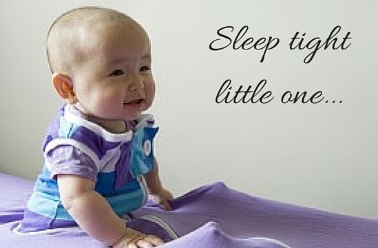 Baby sitting up in purple cosi bed sheet with words sleep tight little one