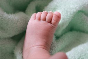 a baby foot on a green blanket