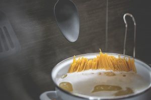 a pot of spaghetti cooking in a saucepan