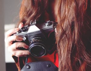 woman with brown hair holding a camera