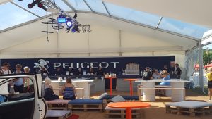 peugeot sign over a bar with seating