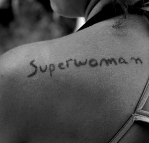 woman's shoulder with superwoman written on it