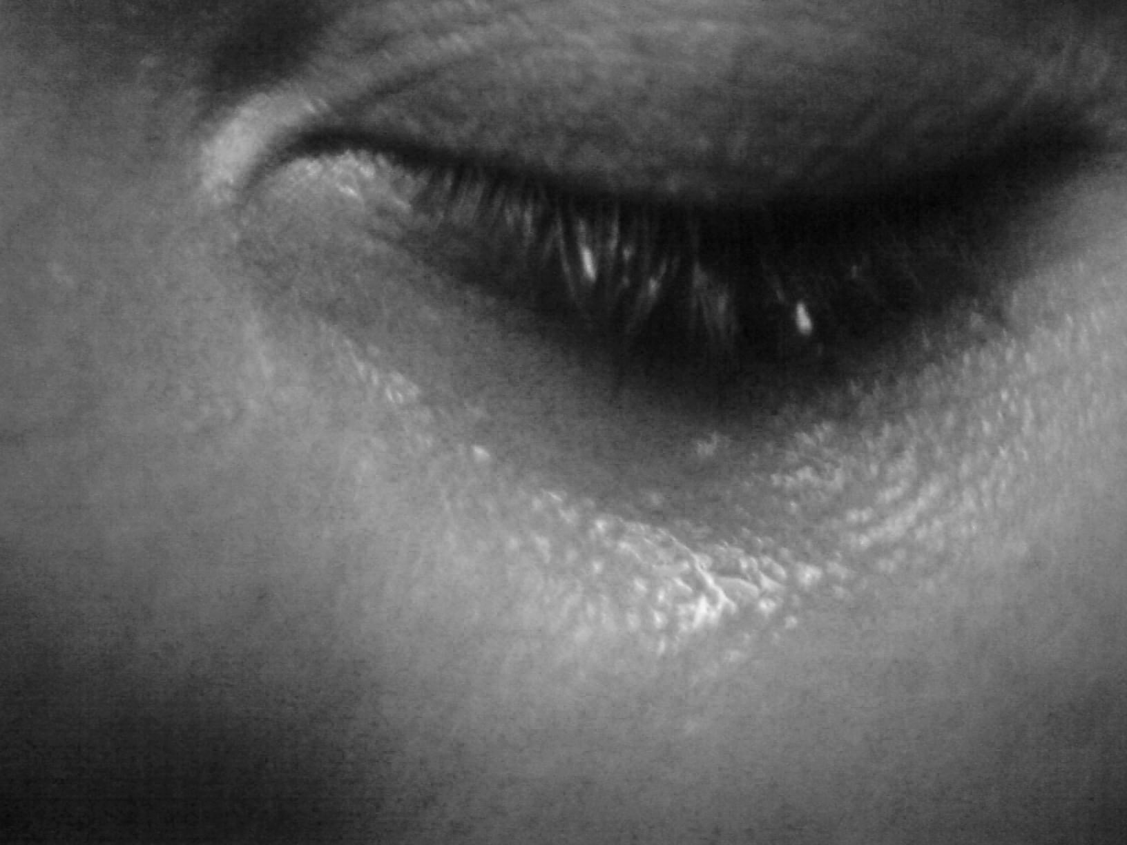 a closed eye with tears on a cheek
