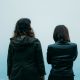 Two girls standing side by side with clouds behind them and title of blog post at the top