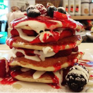 pancakes with fruit and red syrup