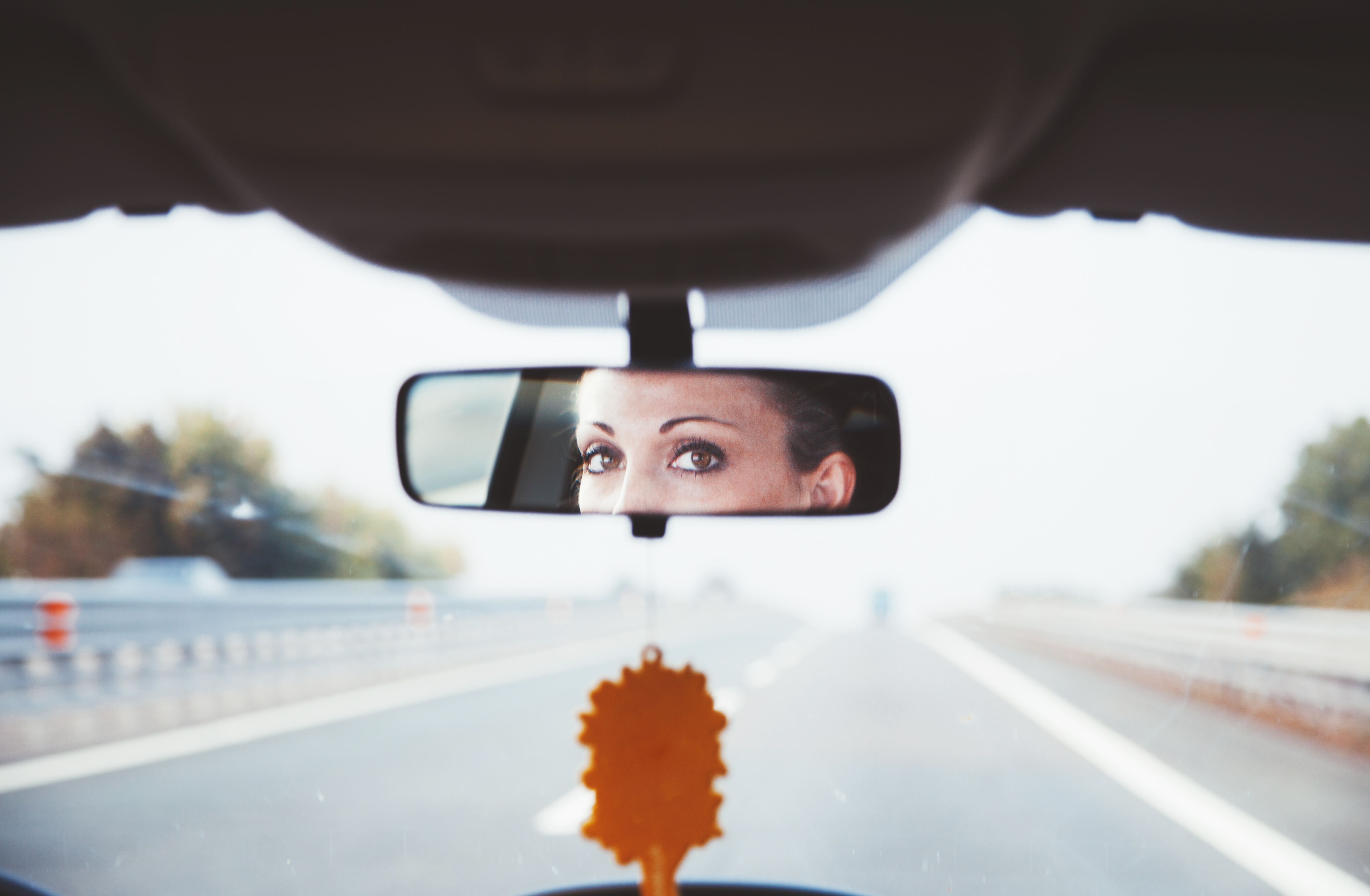 woman looking in rear view mirror