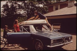 family at a car dad tying something to the roof