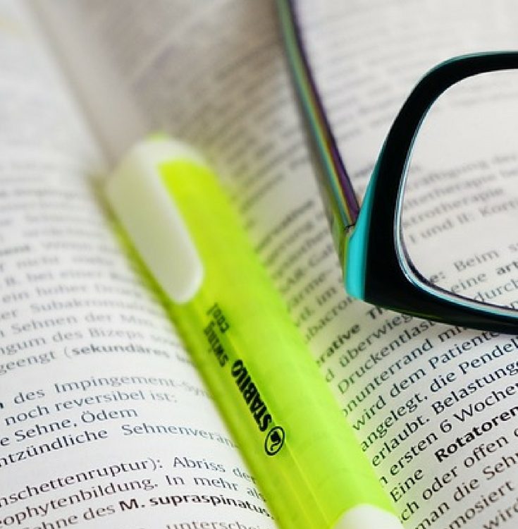 highlighter and glasses in an open book