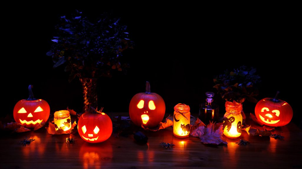 a line of carved pumpkins with different faces all lit