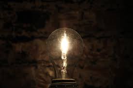 a lit light bulb on a dark background