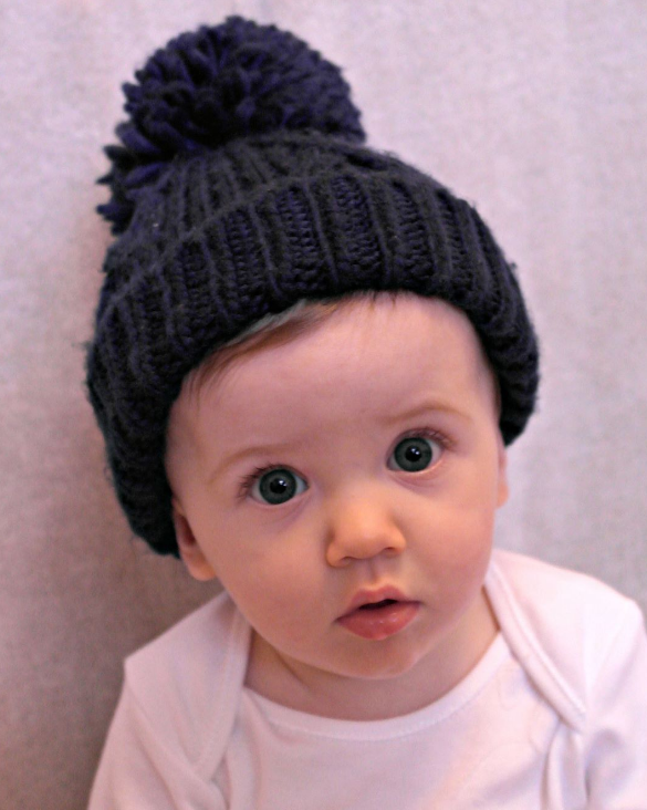 little boy staring at the camera with a bobble hat on