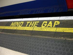 mind the gap sign on the platform of a station