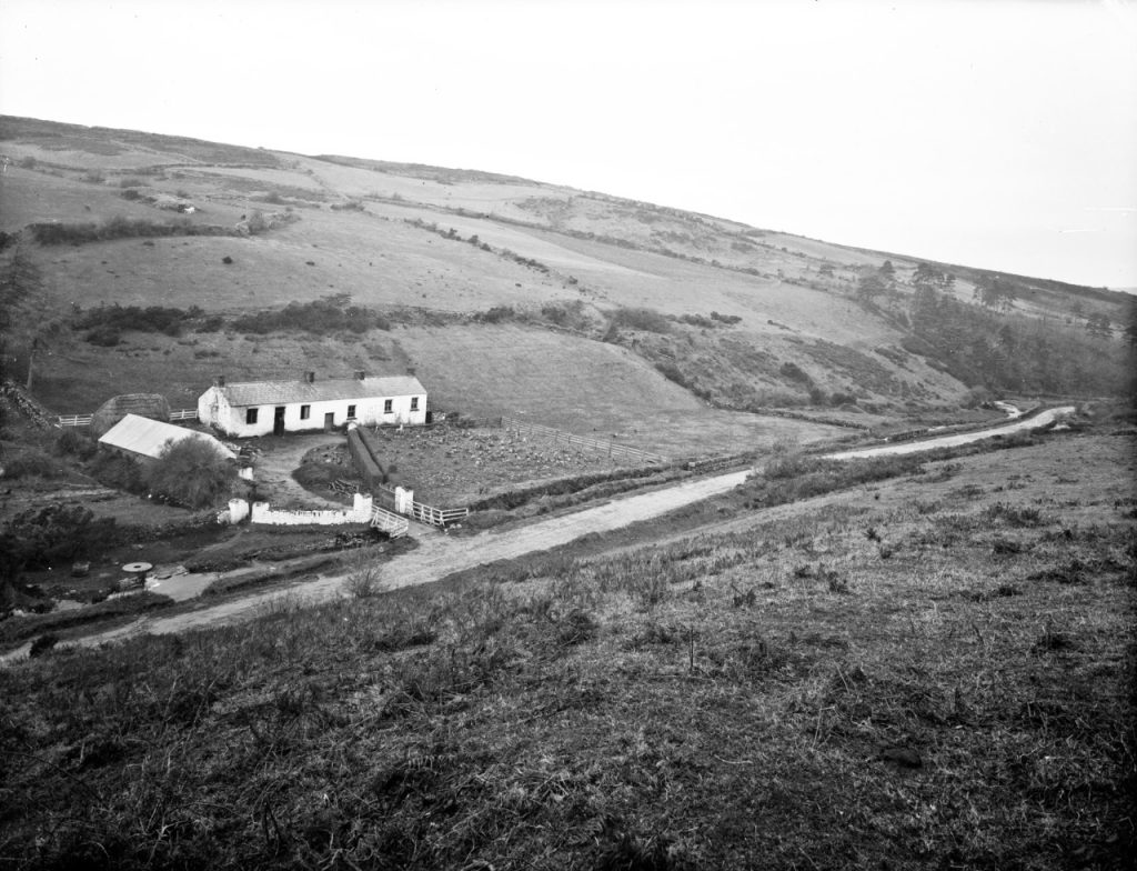 black and white picture of remote cottage on a hill