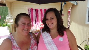 mum and I smiling at the camera in summer both wearing pink under an umbrella at my baby shower