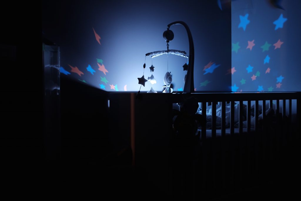 a cot in the dark with a night light over it