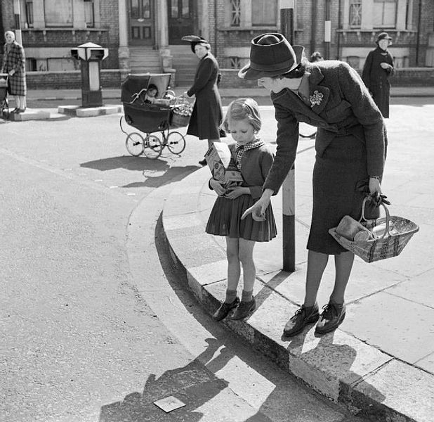 a mother teaching her child to cross the road safely - picture in black and white