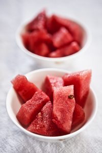 two white bowls with chunks of watermelon in