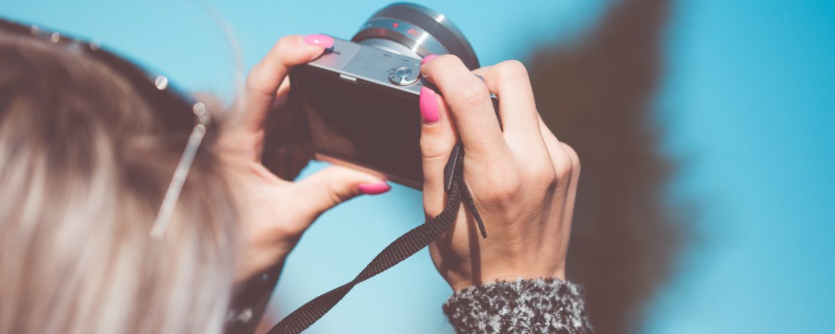 woman taking photos with a blue background