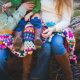a man woman and child in jeans and boots sat on a log with a crochet blanket