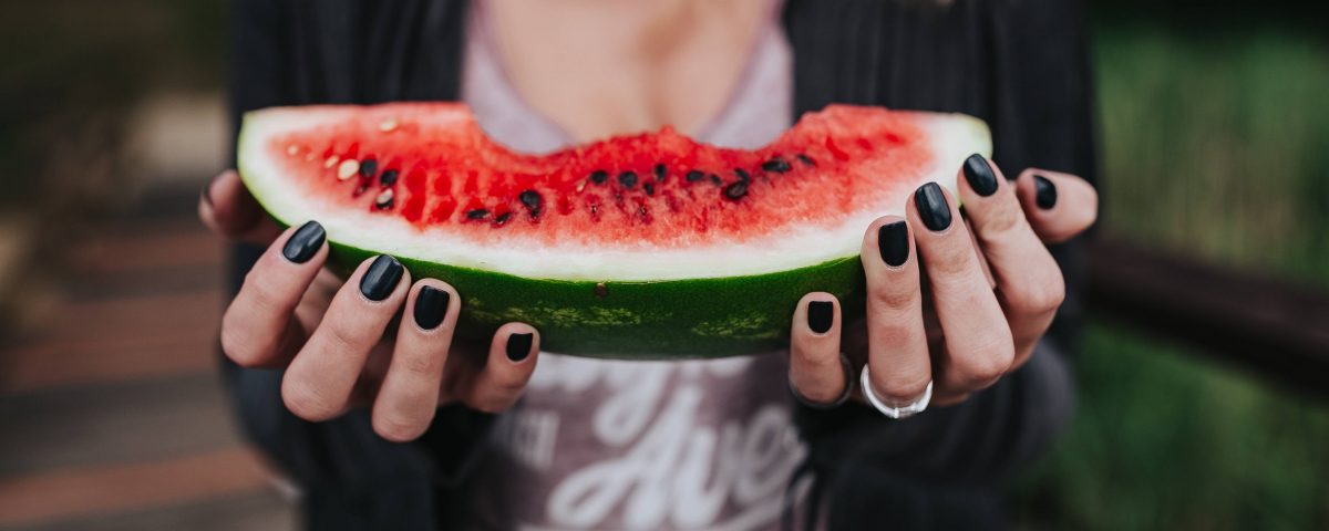 woman holding a watermelon chunk in lockdown