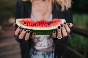 woman holding a watermelon chunk