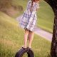 a girl stood on top of a tyre swing hanging from a tree