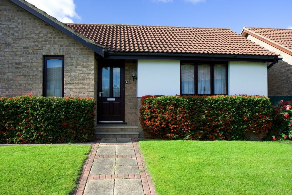a picture of a bungalow with a grass front lawn