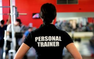 a woman with her back to the camera wearing a tshirt that says personal trainer