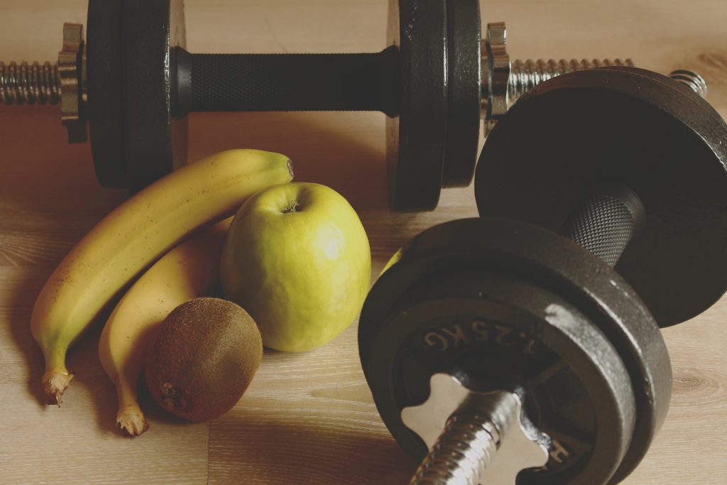 a set of dumbells and some bananas and apples