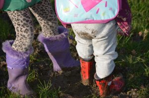 2 sets of childrens wellies in the mud