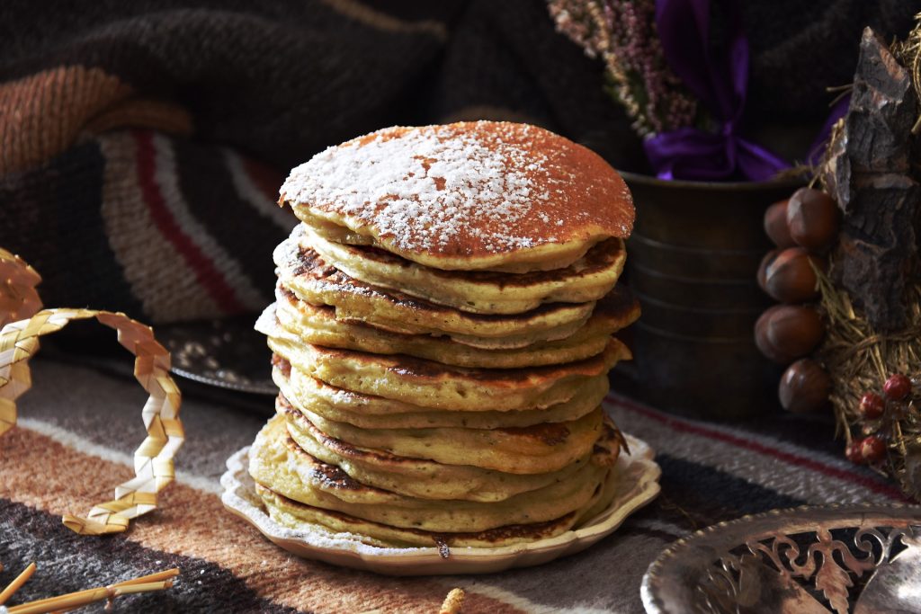 a stack of american style pancakes with icing sugar made from banana. vegan