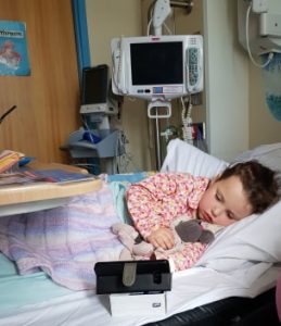 Alyssa lying on her hospital bed post surgery