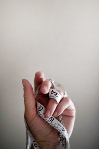 a hand holding a tape measure