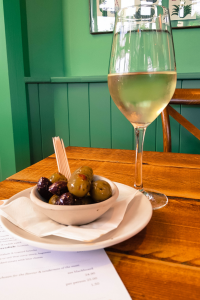 glass of white wine and a bowl of olives at the oaks highcliffe 