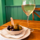 glass of white wine and a bowl of olives at the oaks highcliffe