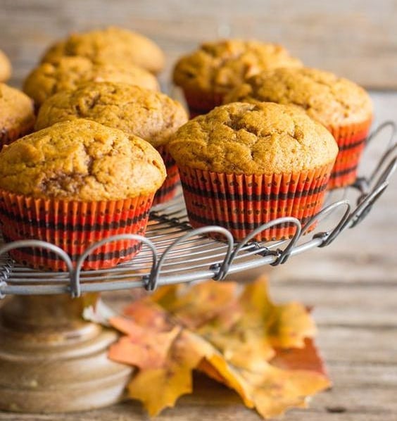 apple pie muffins on a cake stand with some autumn leaves