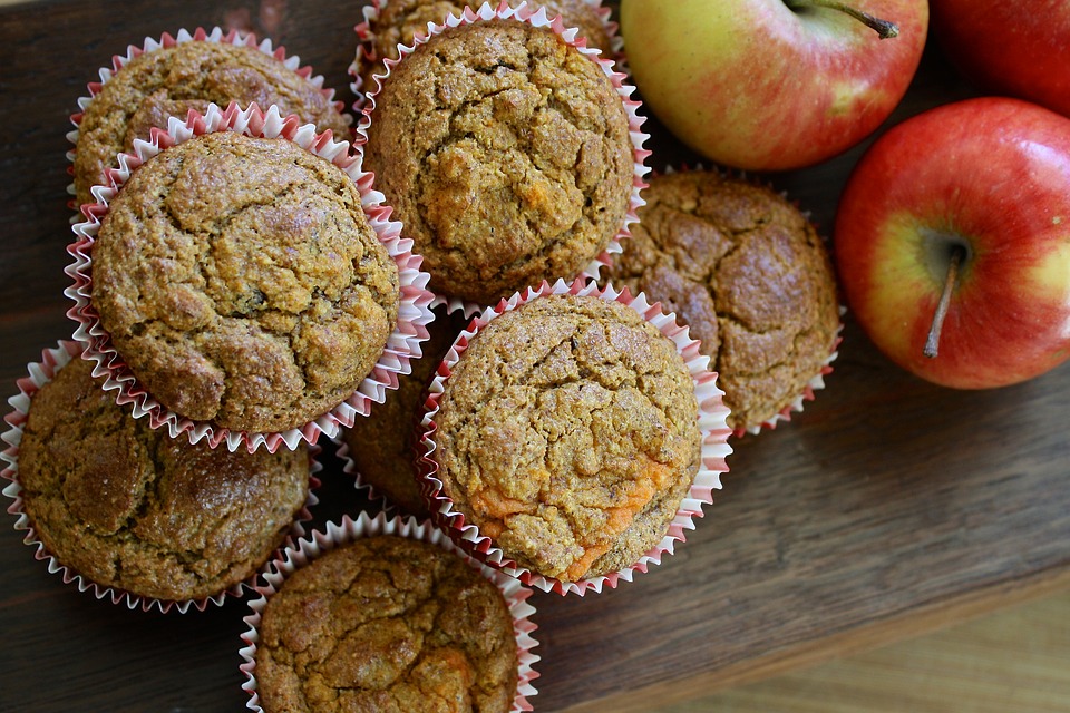 top view of a stack on muffins with some apples