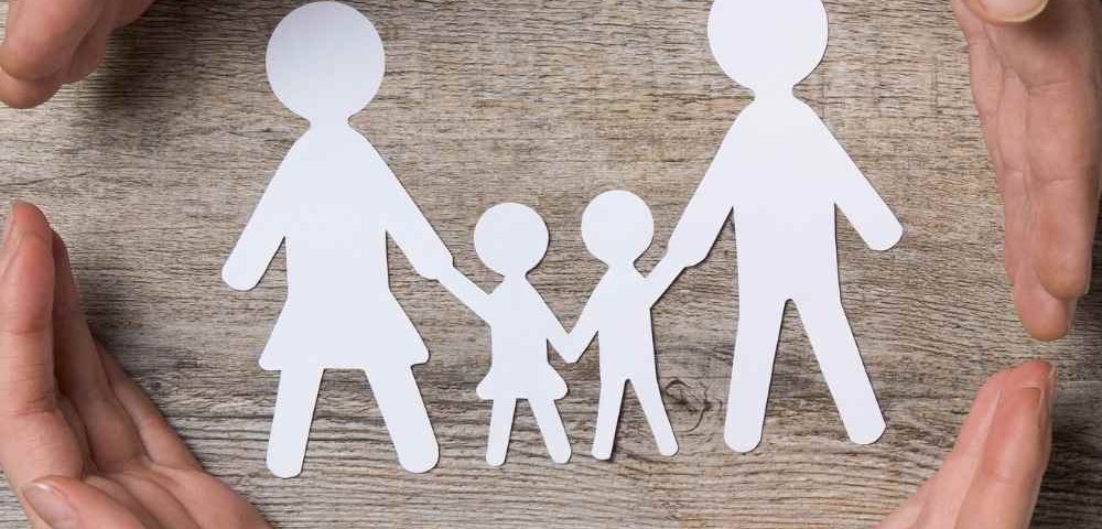 hands around paper cut outs of a working mum and her partner and children