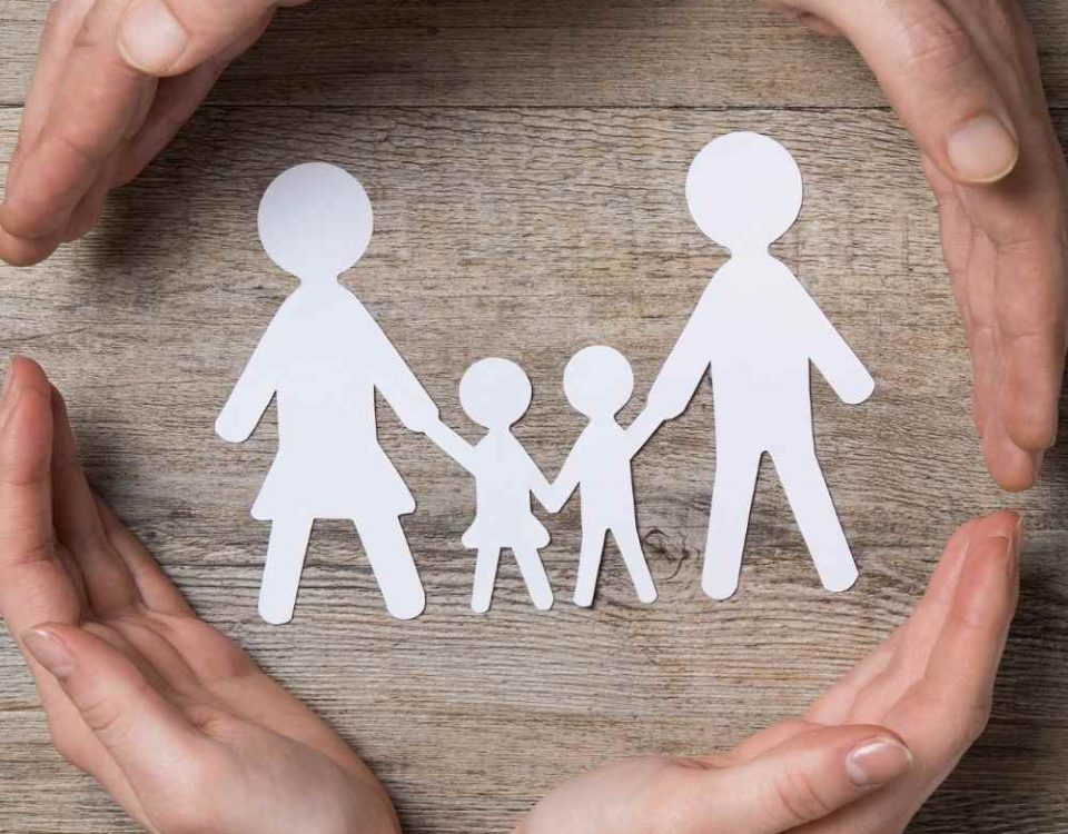 hands around paper cut outs of a working mum and her partner and children