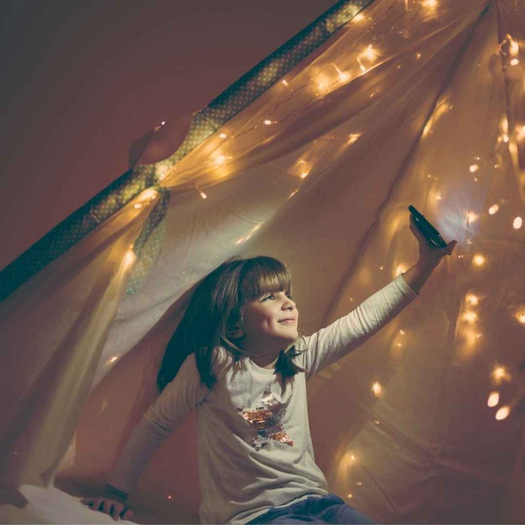 winter fun child in a teepee with twinkle lights