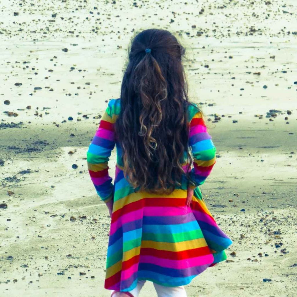 Alyssa on the beach in the childrensalon rainbow dress